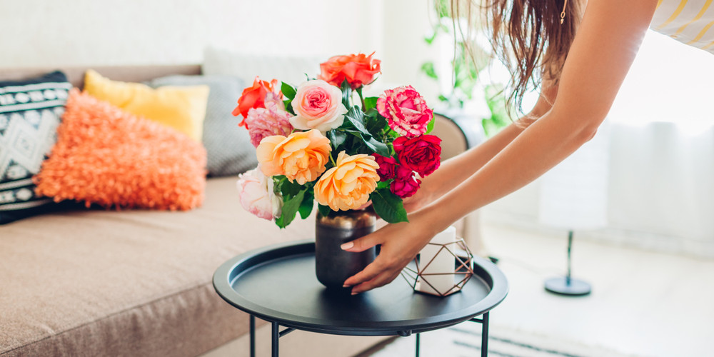 placing a vase of flowers on a coffee table