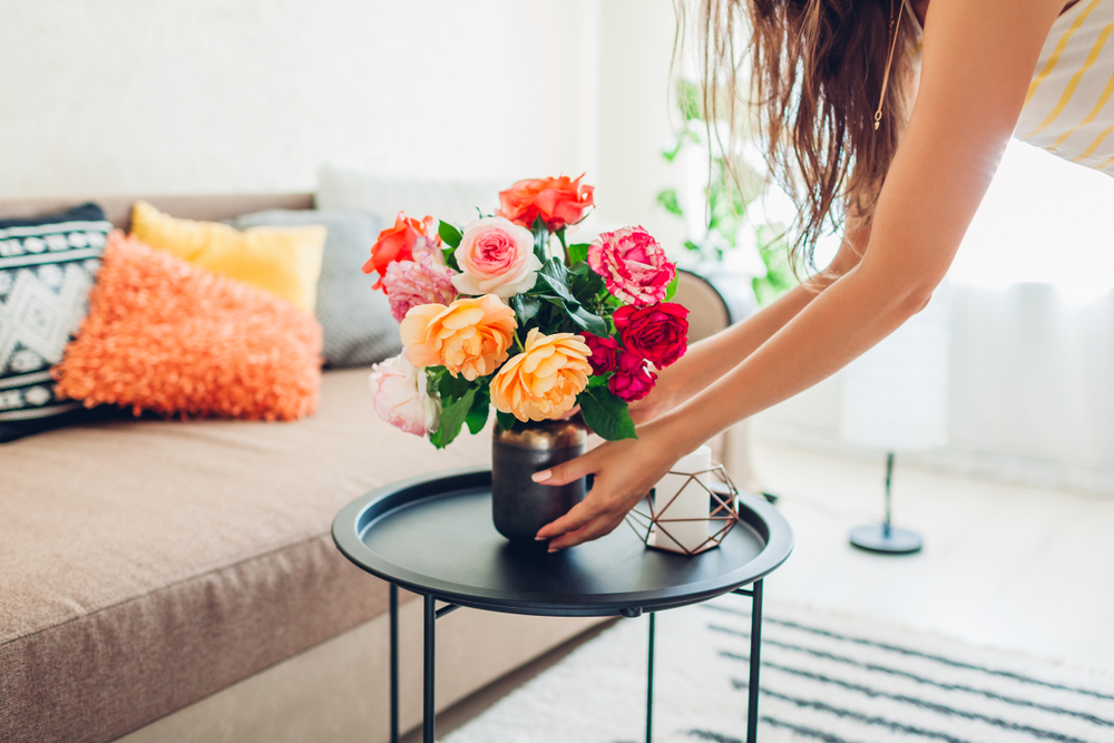 placing a vase of flowers on a coffee table